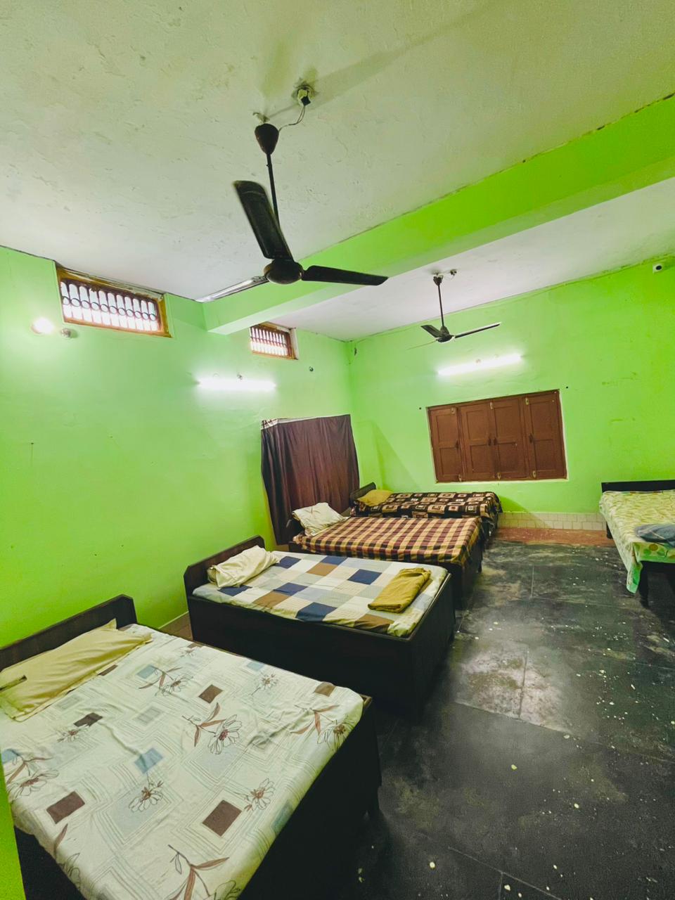 Spacious shared residential room with beds and ceiling fans